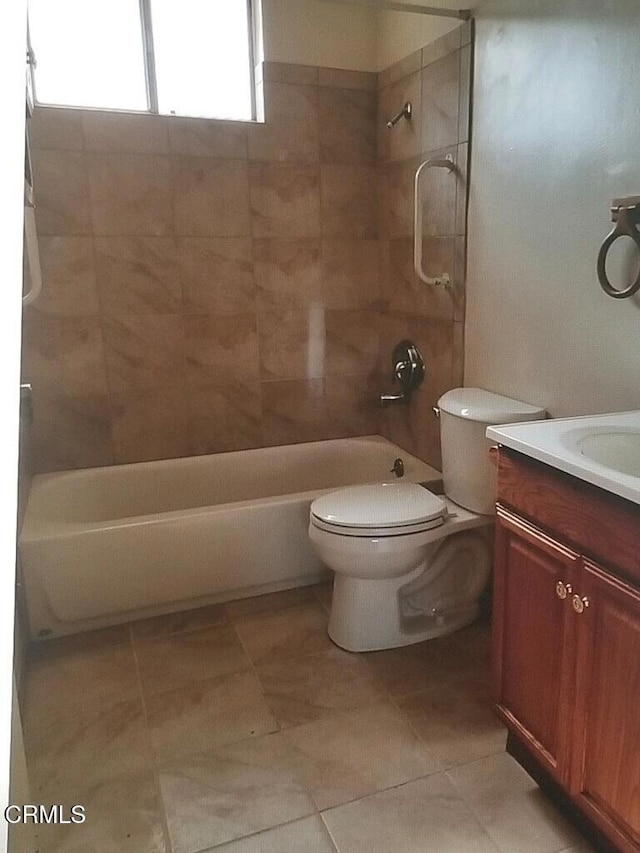 full bathroom featuring tile patterned floors, tiled shower / bath combo, toilet, and vanity