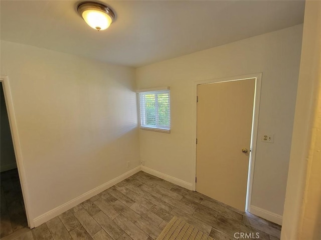 unfurnished room featuring baseboards and wood finished floors