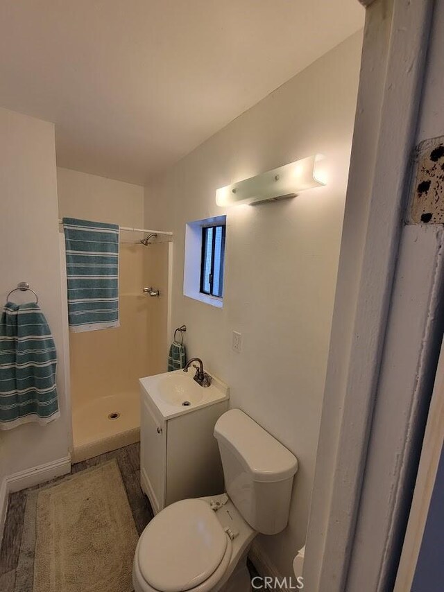 bathroom with toilet, a shower stall, and vanity