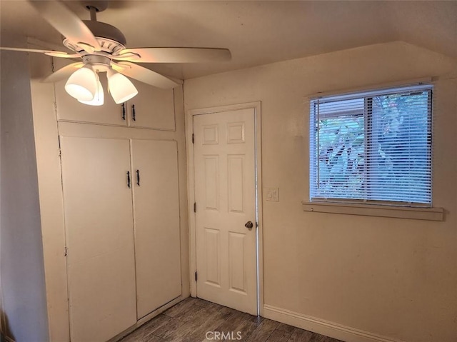 unfurnished bedroom with ceiling fan, a closet, wood finished floors, and baseboards