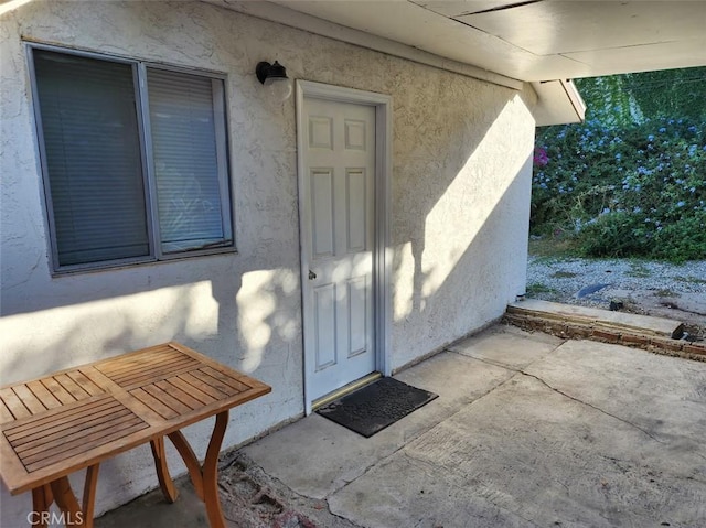 doorway to property with a patio and stucco siding