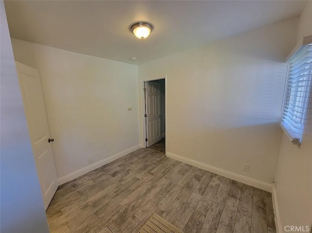 empty room featuring baseboards and wood finished floors