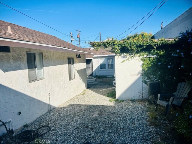 view of property exterior with roof with shingles and stucco siding