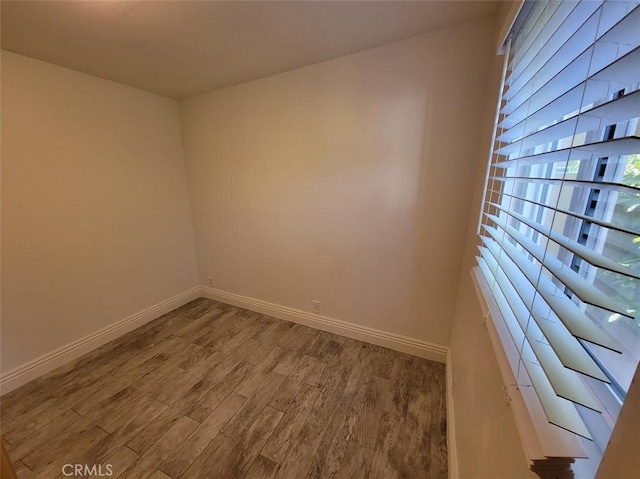 unfurnished room with wood finished floors and baseboards
