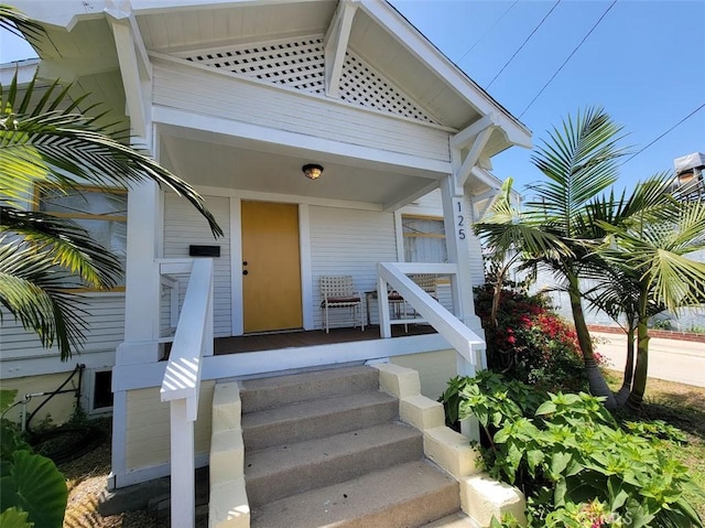 view of exterior entry featuring covered porch