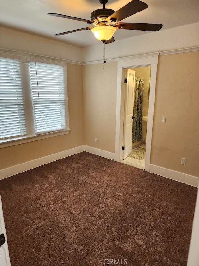 unfurnished bedroom featuring carpet, ceiling fan, ensuite bath, and baseboards