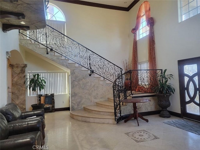 foyer featuring ornamental molding and a towering ceiling