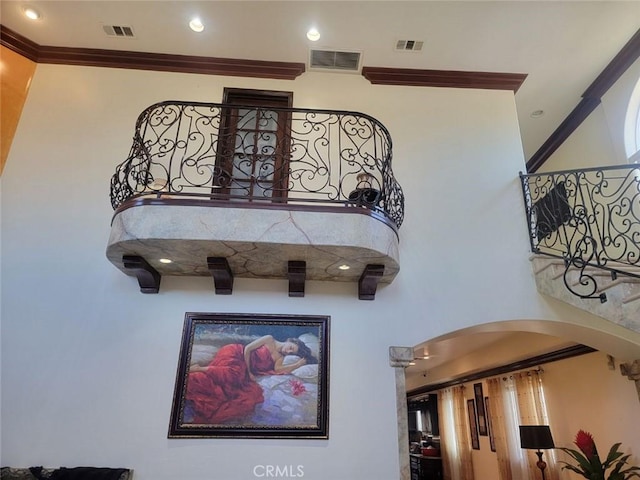 interior space featuring a towering ceiling and ornamental molding