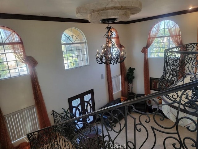 staircase with crown molding and a notable chandelier