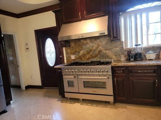 kitchen with range with two ovens, crown molding, a wealth of natural light, and decorative backsplash