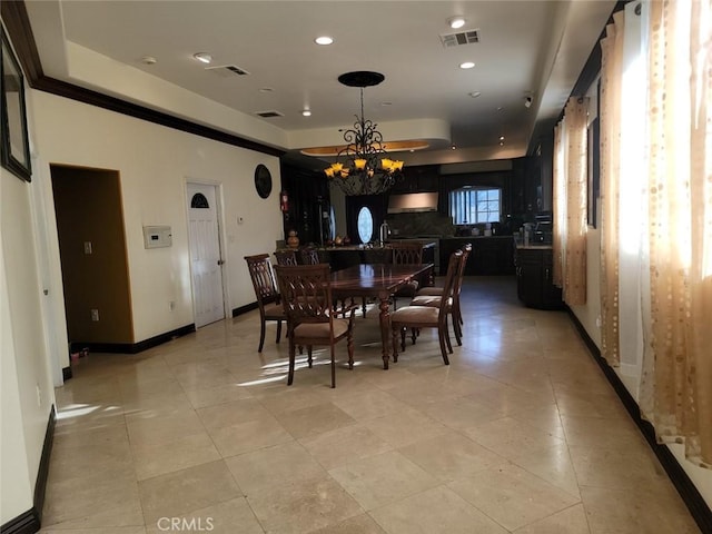 dining space featuring a notable chandelier, sink, a raised ceiling, and light tile patterned flooring