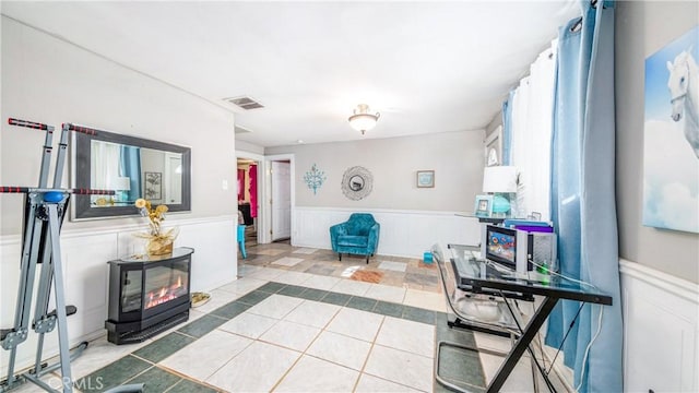 living room with light tile patterned floors and a wood stove