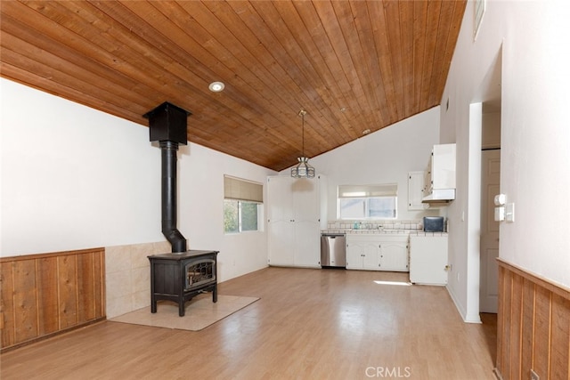 unfurnished living room featuring light wood-type flooring, high vaulted ceiling, a wood stove, and wood ceiling