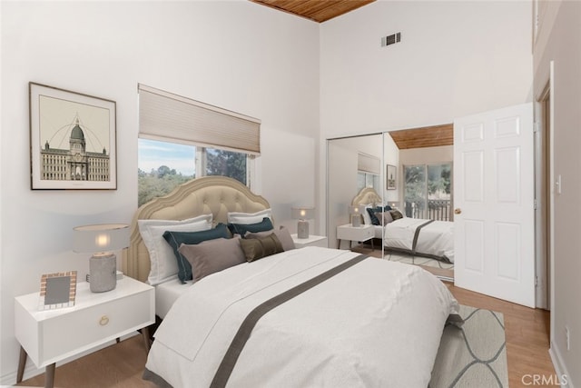 bedroom featuring hardwood / wood-style floors and a towering ceiling