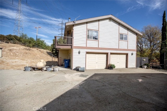 view of property exterior with a garage and a balcony