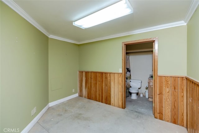 unfurnished room with ornamental molding and wooden walls