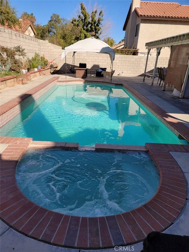 view of pool featuring an in ground hot tub and a patio