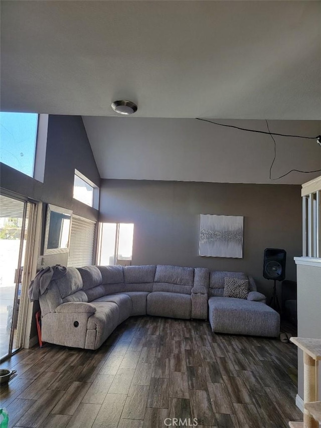 living room with dark hardwood / wood-style flooring and high vaulted ceiling