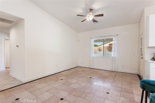 tiled empty room featuring ceiling fan