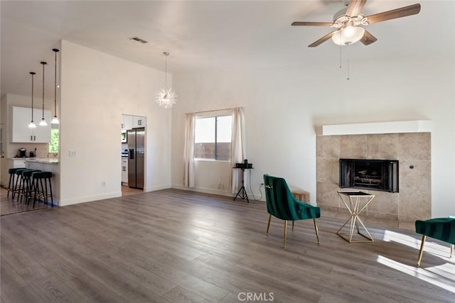 living room featuring ceiling fan with notable chandelier and dark hardwood / wood-style floors