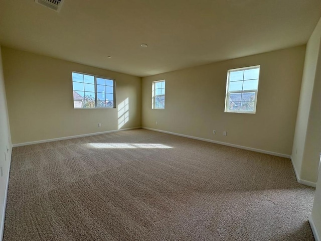 carpeted spare room featuring a healthy amount of sunlight