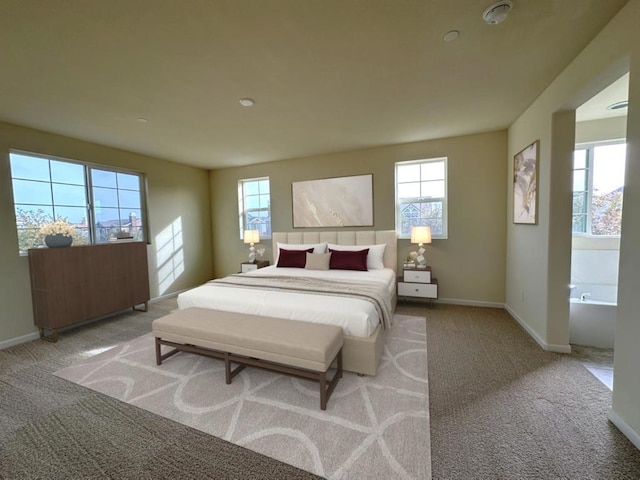 bedroom with light colored carpet and connected bathroom