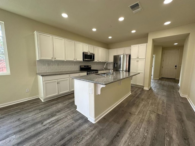 kitchen featuring white cabinetry, a center island with sink, stainless steel appliances, a breakfast bar, and sink