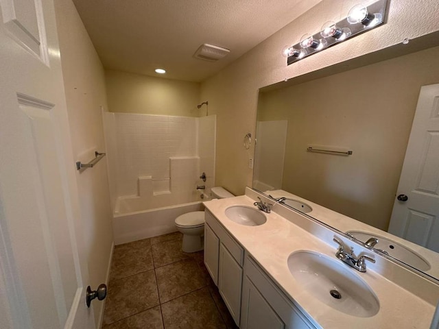 full bathroom featuring toilet, washtub / shower combination, tile patterned flooring, a textured ceiling, and vanity