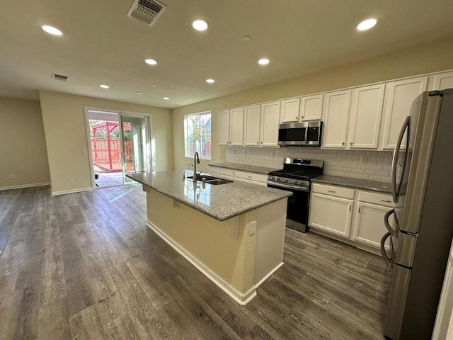 kitchen with appliances with stainless steel finishes, an island with sink, white cabinetry, and sink