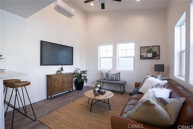 living room with an AC wall unit, ceiling fan, dark hardwood / wood-style flooring, and plenty of natural light