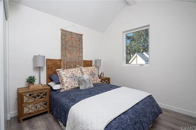 bedroom with vaulted ceiling with beams and dark hardwood / wood-style flooring