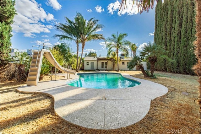 outdoor pool featuring a water slide and a patio area