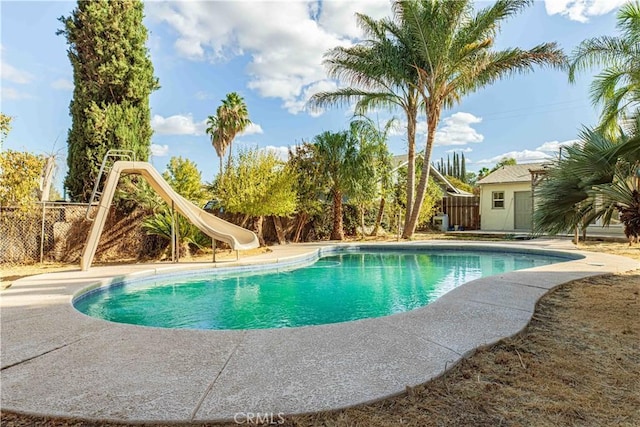 view of swimming pool featuring a fenced in pool, fence, and a water slide