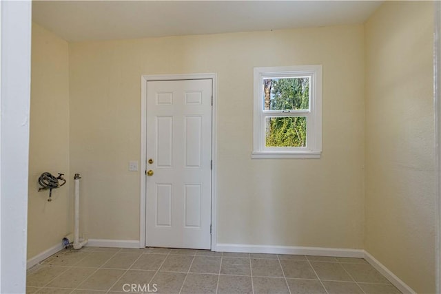 unfurnished room featuring baseboards and light tile patterned floors