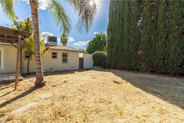 view of yard featuring fence, a pergola, and central AC