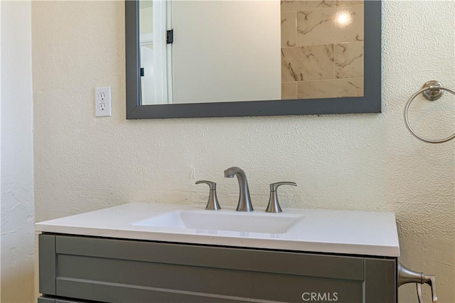 bathroom featuring vanity and a textured wall