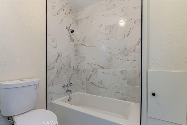 bathroom featuring a textured wall, bathtub / shower combination, and toilet