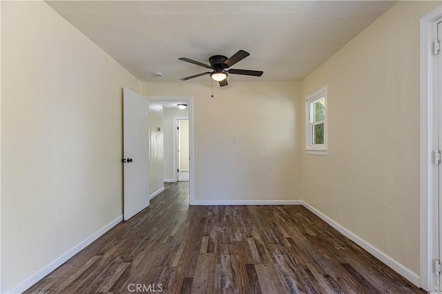 spare room with ceiling fan, baseboards, and dark wood finished floors