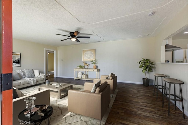 living room featuring baseboards, a textured ceiling, a ceiling fan, and wood finished floors