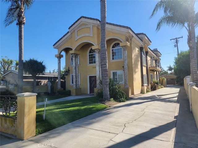 view of front of house with a front yard, an outbuilding, and a garage