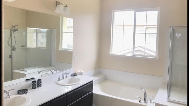 bathroom featuring shower with separate bathtub and vanity