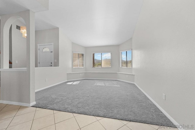 carpeted spare room featuring vaulted ceiling