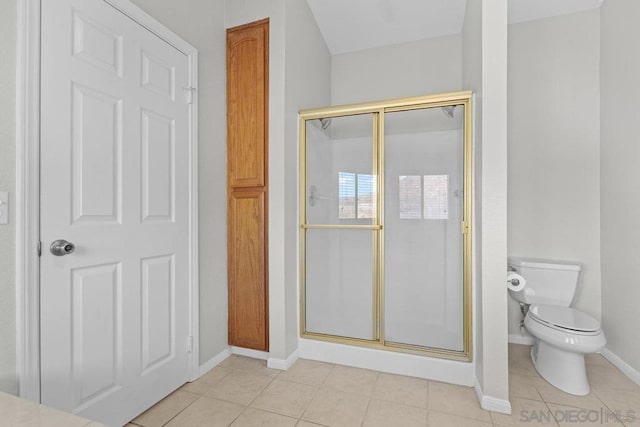 bathroom featuring tile patterned floors, toilet, and an enclosed shower