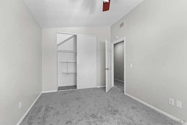 unfurnished bedroom featuring ceiling fan, lofted ceiling, carpet floors, and a closet