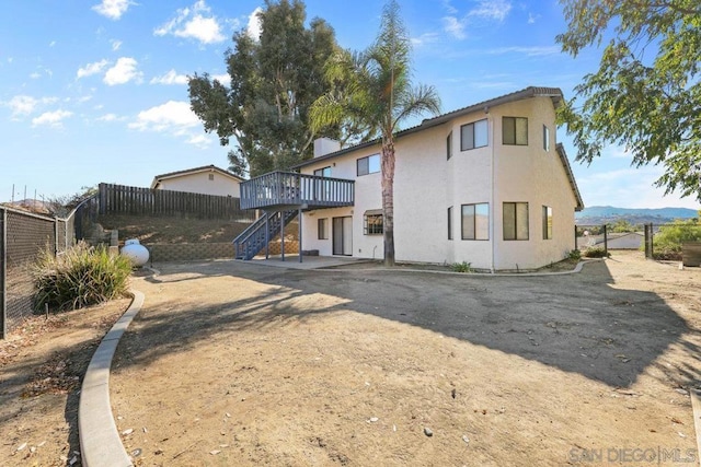 rear view of house with a deck with mountain view