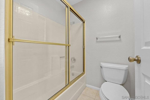 bathroom featuring tile patterned floors, toilet, and enclosed tub / shower combo