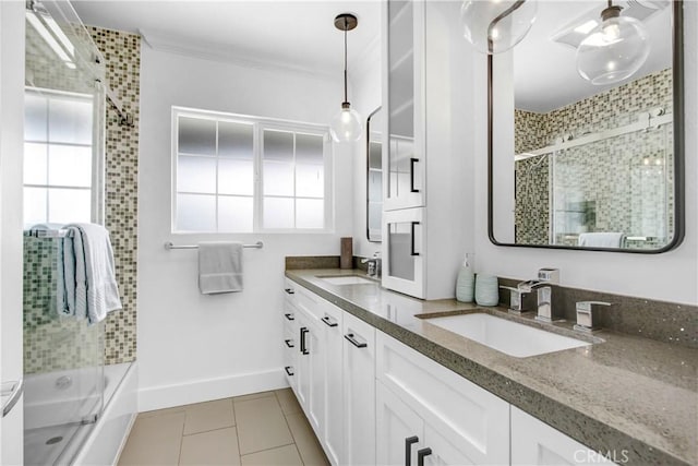 bathroom with tile patterned flooring, vanity, ornamental molding, and bath / shower combo with glass door