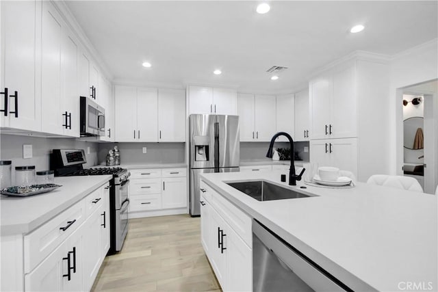 kitchen with white cabinets, sink, light wood-type flooring, and stainless steel appliances