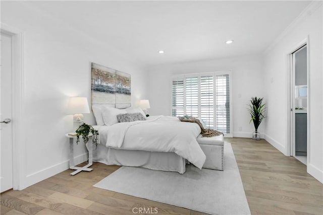 bedroom with light hardwood / wood-style floors and crown molding