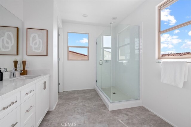 bathroom with vanity, a wealth of natural light, and a shower with shower door